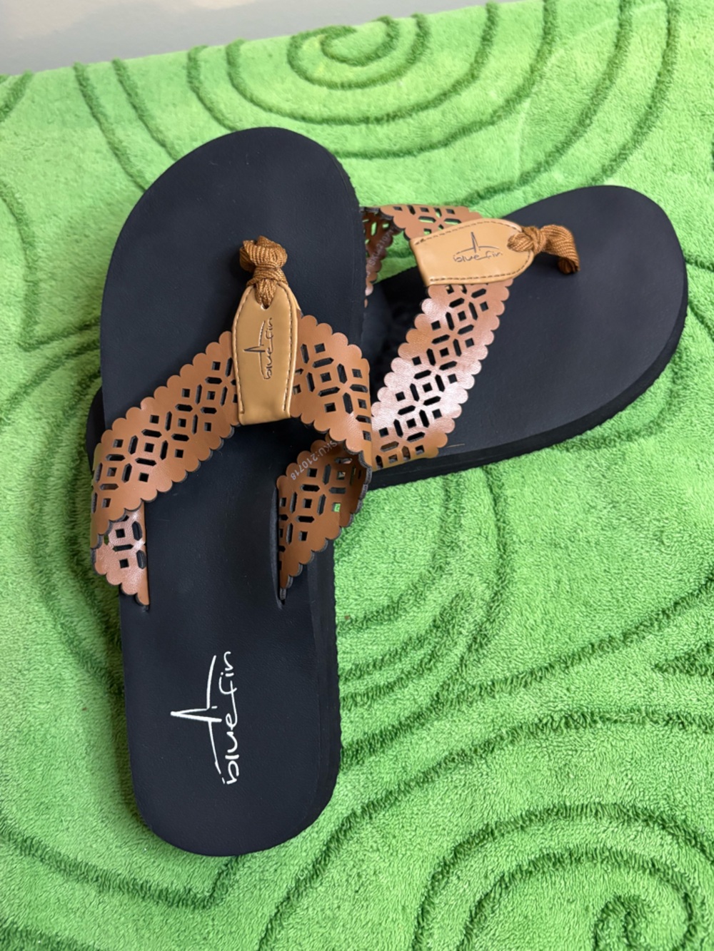 Blue Fin brand black flip-flop sandals with brown laser-cut scalloped straps.